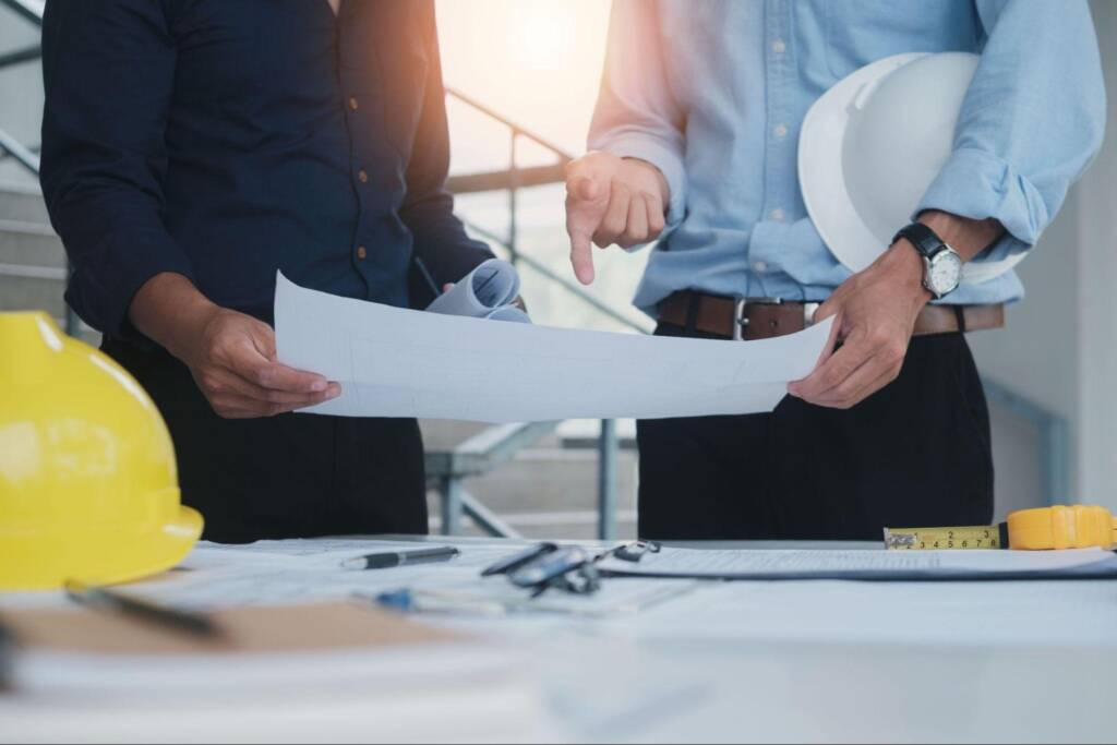 Photo de personnes réfléchissants aux normes et réglementations pour la construction d'un bâtiment industriel