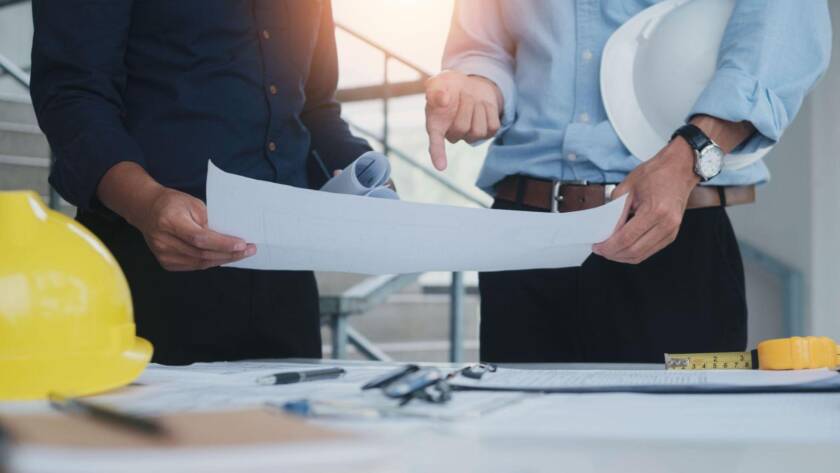 Photo de personnes réfléchissants aux normes et réglementations pour la construction d'un bâtiment industriel